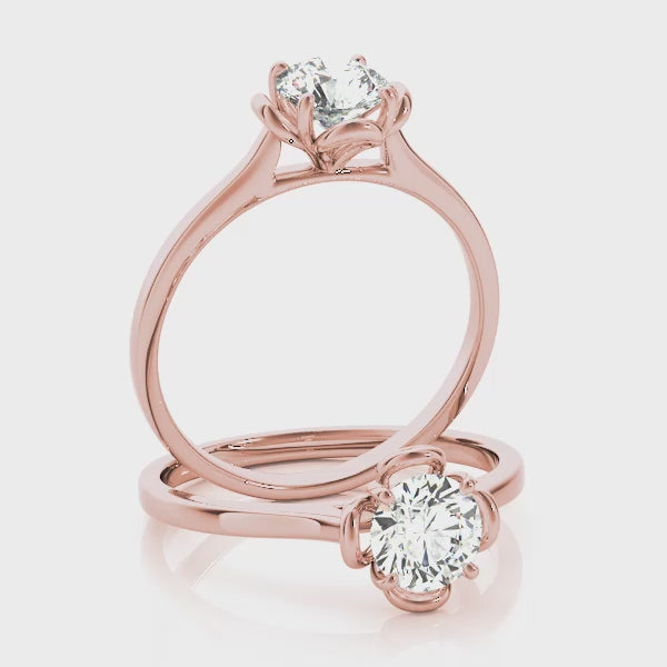 A 360-degree video showcasing two 14K rose gold rings, highlighting the brilliant VS F diamond and the detailed petal design from all angles.