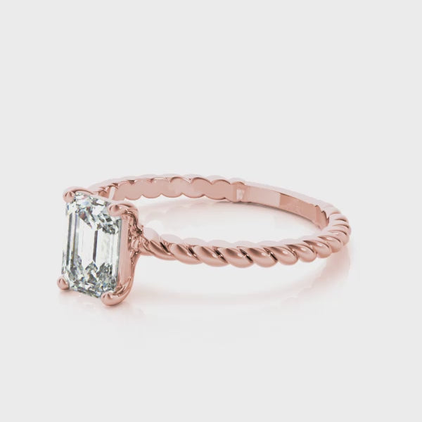 360-degree rotation of rose gold emerald cut diamond ring with twisted band